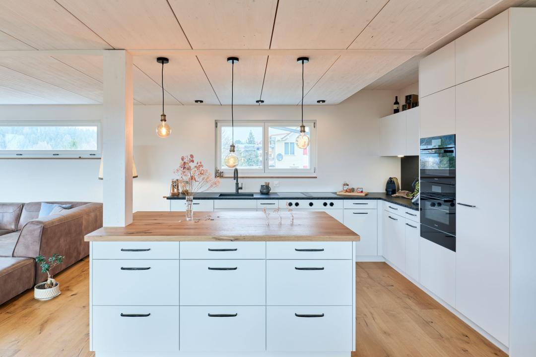 Küche mit Granit-Arbeitsflächen und Kochinsel in Heimberg